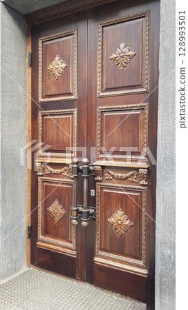 Ornate Dark Wooden Double Door with Intricate Carvings Ornate Dark Wooden Double Door with Intricate Carvings 128993501