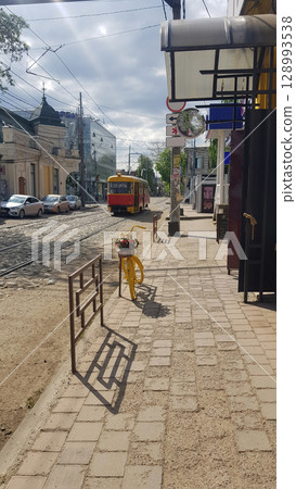 Colorful Tram and Decorative Bicycle on a City Street 128993538