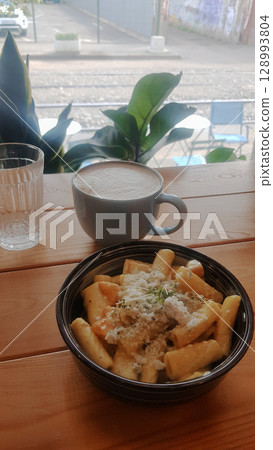 Delicious Pasta, Coffee Latte, and Water on a Cafe Wooden Table Delicious Pasta, Coffee Latte, and Water on a Cafe Wooden Table 128993804