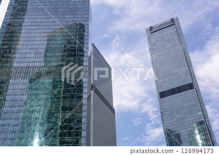 Modern skyscrapers on a blue sky background Modern skyscrapers on a blue sky background 128994173