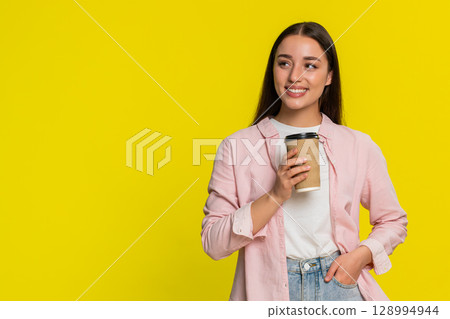 Woman holding takeaway coffee cup sipping drink, enjoying aroma satisfied relaxed happy expression Woman holding takeaway coffee cup sipping drink, enjoying aroma satisfied relaxed happy expression 128994944