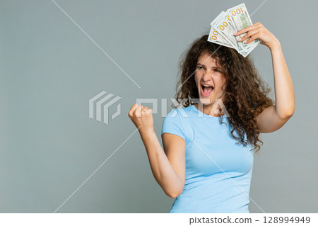 Woman hold dollar cash money smiling satisfied celebrating salary savings loan financial success joy 128994949