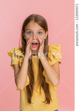Child girl kid screaming with hands around mouth pretending to use loudspeaker call someone loudly Child girl kid screaming with hands around mouth pretending to use loudspeaker call someone loudly 128994971