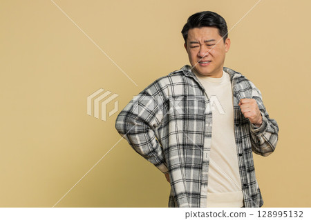 Man touching injured sore back, backache, suffering lower lumbar discomfort, muscle pain of overwork Man touching injured sore back, backache, suffering lower lumbar discomfort, muscle pain of overwork 128995132