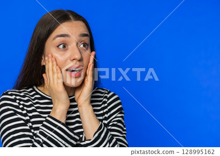 Excited amazed woman surprise looking at right with big eyes, shocked by sudden victory wow emotion 128995162