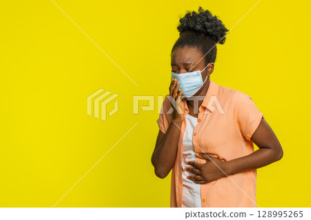 African American woman putting on medical mask tired expression covering nose and mouth health focus 128995265