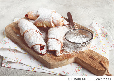 bagels with filling, sweet pastries, sprinkled with powdered sugar, on a wooden board, dessert, breakfast, bagels with filling, sweet pastries, sprinkled with powdered sugar, on a wooden board, dessert, breakfast, 128995353