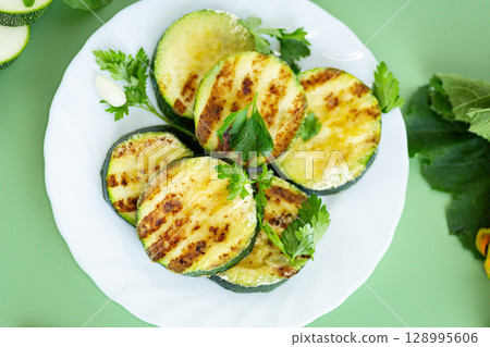 Close-up of fried zucchini on a green background 128995606