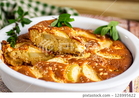 Homemade charlotte with apples and sesame sprinkles in a white mold 128995622