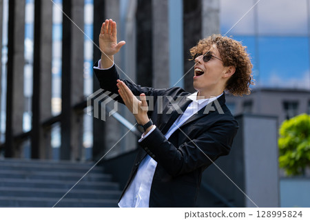 Happy rich businessman showing money gesture, wasting throwing money cash around earnings donation 128995824