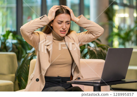 Caucasian businesswoman girl using laptop surprised by bad news, fortune loss, fail, lottery results 128995857