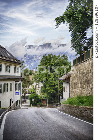 Empty road leading to the italian Dolomites mountains, Collalbo Italy 128996107