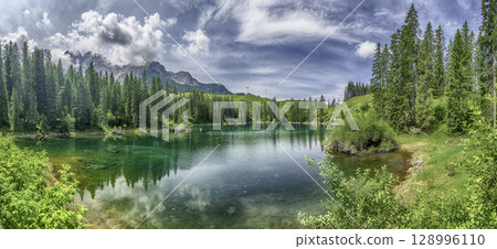 The emerald green Lake Carezza reflecting Latemar mountain, Dolomites, Italy The emerald green Lake Carezza reflecting Latemar mountain, Dolomites, Italy 128996110