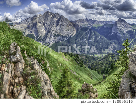 Marmolada mountain range towering over green valley, Dolomites, Italy 128996116