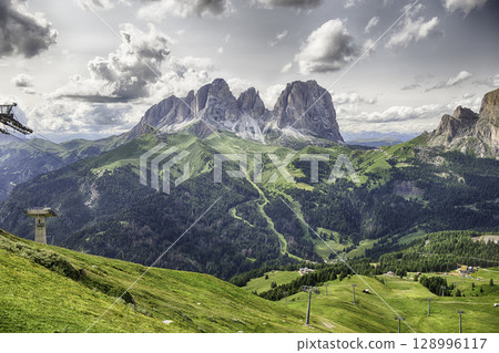 Langkofel group mountains towering over lush green valleys in Italy Langkofel group mountains towering over lush green valleys in Italy 128996117