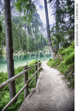Hiking trail along Lake Braies in the Dolomites mountains, Italy 128996138