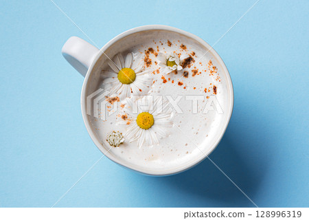Chamomile moon milk on blue background Chamomile moon milk on blue background 128996319
