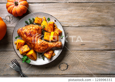 Oven roasted chicken quarter and pumpkin 128996331