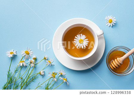 Chamomile tea cup with honey and chamomile flowers 128996338