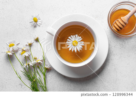 Chamomile tea cup with honey and chamomile flowers 128996344