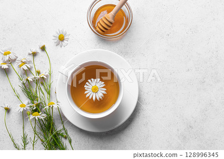 Chamomile tea cup with honey and chamomile flowers 128996345