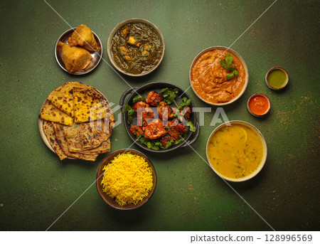 Traditional Indian dishes top view on green background table. Cuisine of India Traditional Indian dishes top view on green background table. Cuisine of India 128996569