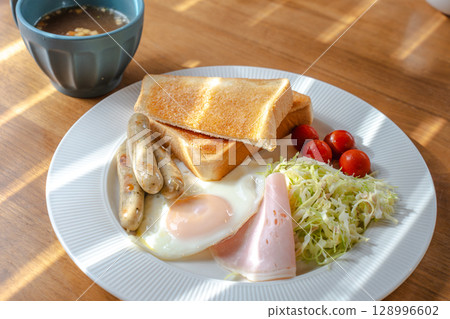 Western-style breakfast set with toast, fried egg, sausage and salad 128996602