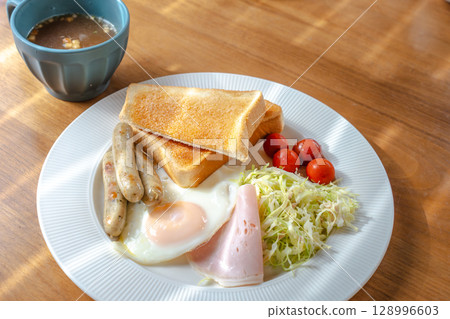 Western-style breakfast set with toast, fried egg, sausage and salad 128996603