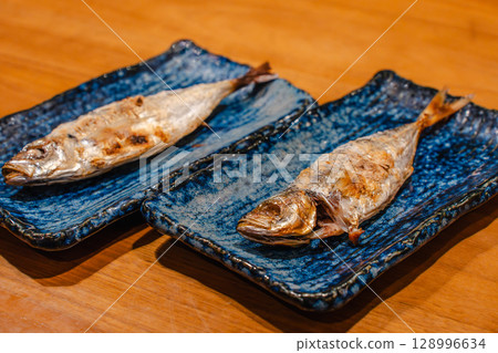 晚餐主菜是盛在日式藍色盤子裡的鹽烤竹莢魚 晚餐主菜是盛在日式藍色盤子裡的鹽烤竹莢魚 128996634