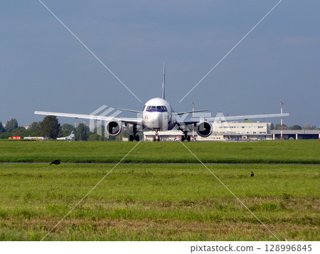 plane taxiing on the airport runway plane taxiing on the airport runway 128996845
