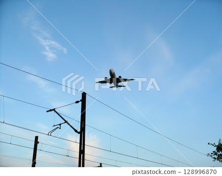 A passenger plane against the blue sky takes off from the airport A passenger plane against the blue sky takes off from the airport 128996870