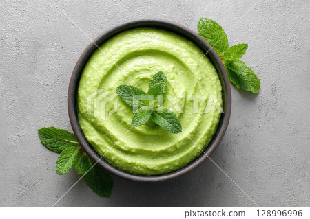 Green Pea and Mint Mash in Bowl with Herb Garnish on Neutral Background Green Pea and Mint Mash in Bowl with Herb Garnish on Neutral Background 128996996