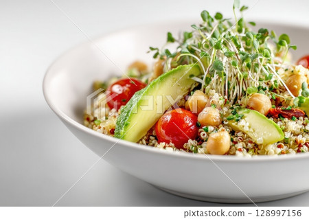 Photorealistic Quinoa Salad with Chickpeas, Avocado, and Microgreens on White Background 128997156