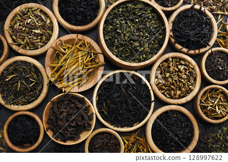 Colorful mix of tea varieties: red and black, green and white, oolong and herbal, selective focus, shallow DOF 128997622