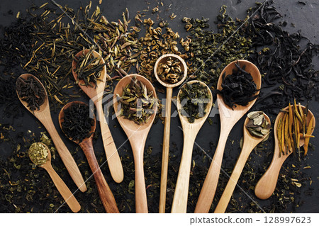 Colorful mix of tea varieties: red and black, green and white, oolong and herbal, selective focus, shallow DOF 128997623