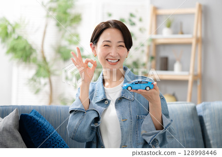 A woman holding a car 128998446