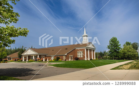 Classic Church Building with Green Lawn and Steeple 128999088