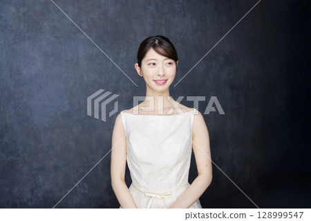 Woman in her 20s, black background, portrait 128999547