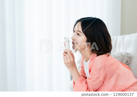 觀看在沙發的一位小姐一個智能手機 129000137