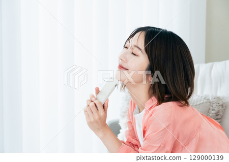 觀看在沙發的一位小姐一個智能手機 129000139