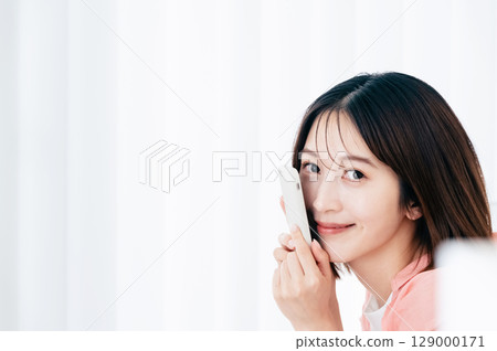 觀看在沙發的一位小姐一個智能手機 129000171