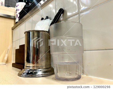 餐廳的櫃檯座位，櫃檯上放著玻璃杯和餐巾 129000298