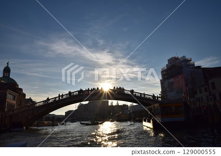 Silhouette of a bridge, sparkling water and dazzling sun (Venice, Italy) Silhouette of a bridge, sparkling water and dazzling sun (Venice, Italy) 129000555