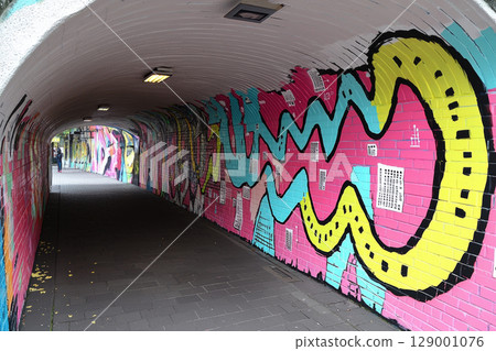 vibrant mural featuring colorful patterns and designs on tunnel wall, creating energetic atmosphere vibrant mural featuring colorful patterns and designs on tunnel wall, creating energetic atmosphere 129001076