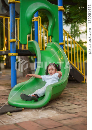 happy toddler baby girl sliding and playing at playground happy toddler baby girl sliding and playing at playground 129001431