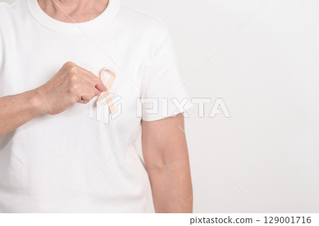 Elderly woman with Peach Ribbon for September Uterine Cancer Awareness month, Endometrial Cancer, Gynecologic, Uterus and Ovaries, Endometriosis, June Vaginal cancer and World cancer day concept 129001716