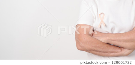 Elderly woman with Peach Ribbon for September Uterine Cancer Awareness month, Endometrial Cancer, Gynecologic, Uterus and Ovaries, Endometriosis, June Vaginal cancer and World cancer day concept 129001722