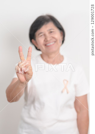 Elderly woman with Peach Ribbon for September Uterine Cancer Awareness month, Endometrial Cancer, Gynecologic, Uterus and Ovaries, Endometriosis, June Vaginal cancer and World cancer day concept 129001728