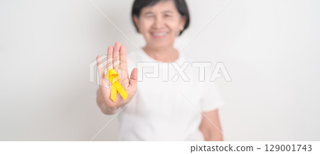 Elderly with Yellow Ribbon for concept of yellow September, Suicide prevention day, Childhood, Pediatric, bone and bladder cancer Awareness month, support survivor. Healthcare and World Cancer day Elderly with Yellow Ribbon for concept of yellow September, Suicide prevention day, Childhood, Pediatric, bone and bladder cancer Awareness month, support survivor. Healthcare and World Cancer day 129001743
