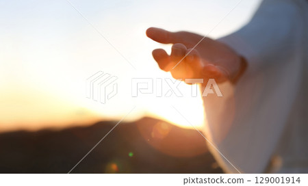 The hand of Jesus Christ reaching out with arms outstretched, the hand gesture of Jesus who died on the cross and was resurrected, heaven, salvation and Easter background The hand of Jesus Christ reaching out with arms outstretched, the hand gesture of Jesus who died on the cross and was resurrected, heaven, salvation and Easter background 129001914